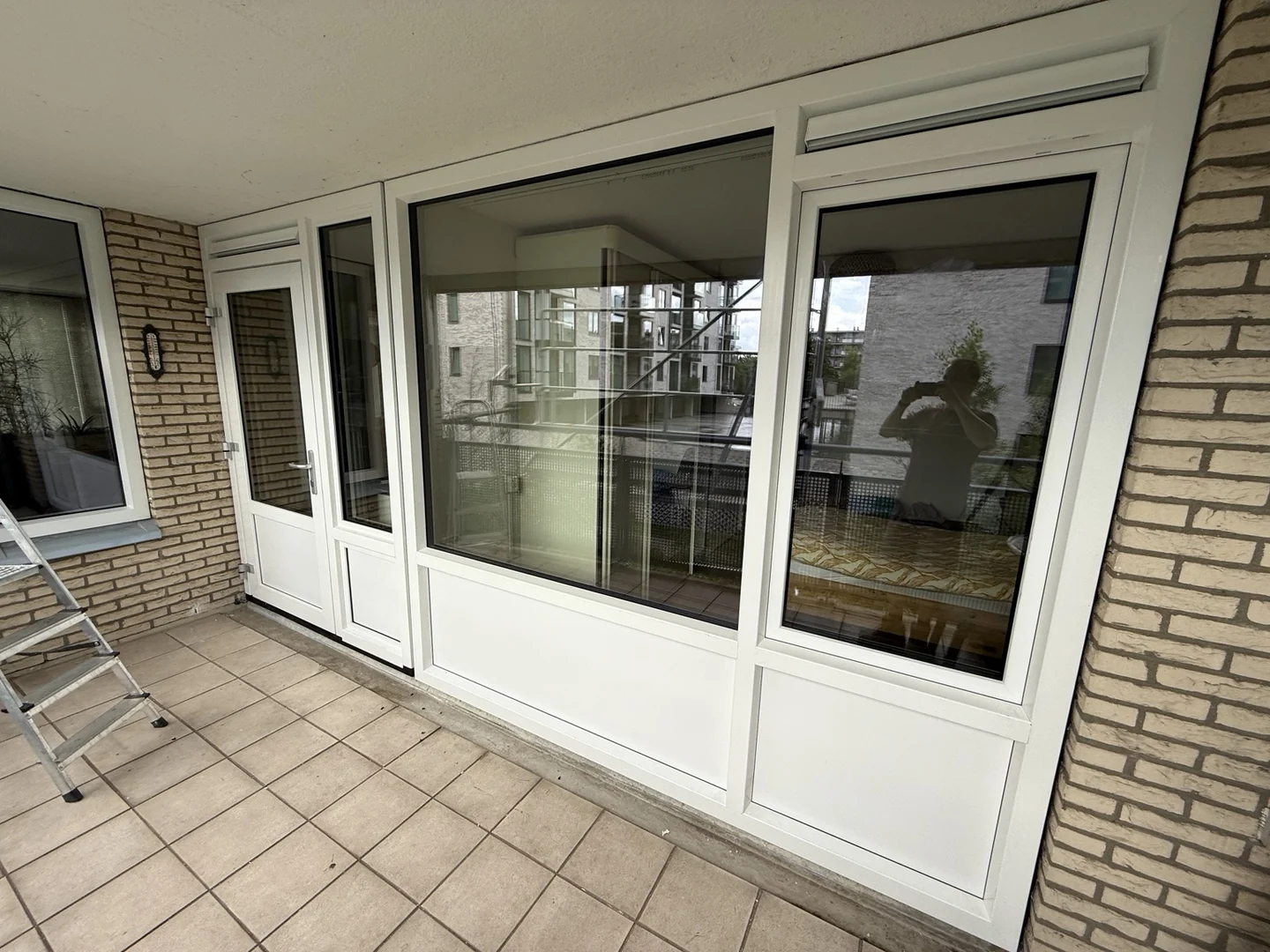 Gemonteerde witte kozijnen en deur aan een balkon
